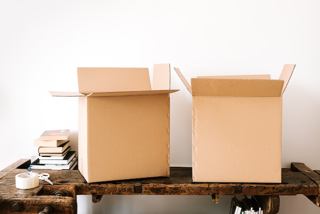 Two empty cardboard boxes sitting on a console table